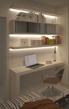 a white desk with a laptop on top of it next to a bookshelf