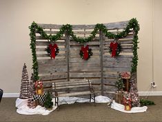 a christmas display with wooden slats and wreaths on the top, along with other decorations