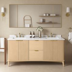 a bathroom vanity with two sinks and mirrors