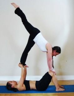 a man and woman doing yoga poses on a blue mat