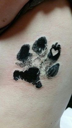 a black and white paw print on the back of a woman's shoulder