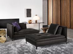 a living room filled with black furniture and lots of wood paneled wall panels on the walls