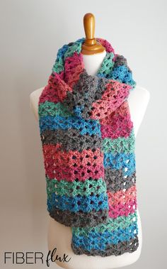 a multicolored crocheted scarf on a mannequin