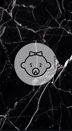 a black and white marble wall with a cartoon bear on it's face in the center