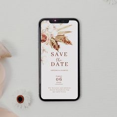 an iphone case sitting on top of a white table next to flowers and a vase