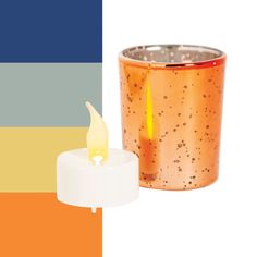 an orange candle is next to a small copper cup with a white candle in it