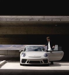 a man standing next to a white car