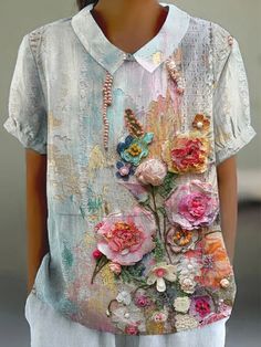 a woman wearing a white shirt with flowers on it