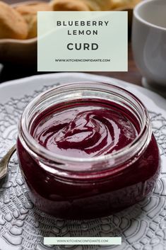 a spoon sitting on top of a white plate next to a jar of red liquid