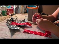 a woman is cutting up some paper with scissors and tape on the table in front of her