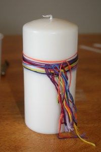 a white candle sitting on top of a wooden table