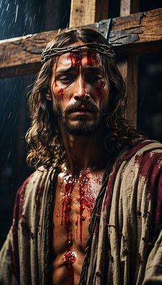 a man with blood all over his face and chest standing in front of a cross