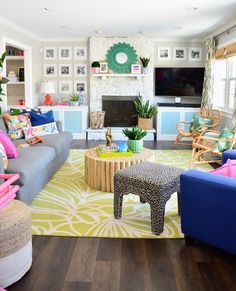 a living room filled with furniture and a flat screen tv mounted on the wall above a fire place