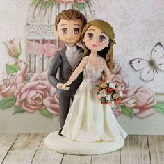 a wedding cake topper with a bride and groom in front of a birdcage