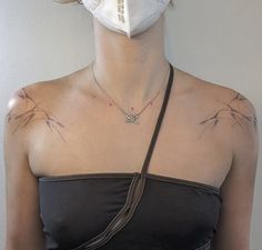 a woman wearing a face mask to protect herself from the sun with tattoos on her chest