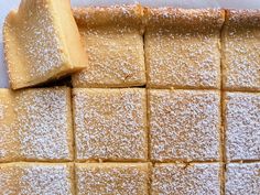 several pieces of cake sitting next to each other on a white tablecloth covered with powdered sugar