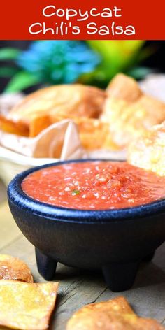 a bowl of salsa with tortilla chips on the side