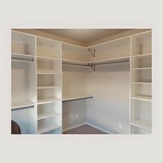 an empty walk in closet with white shelving and no door for any items to be opened