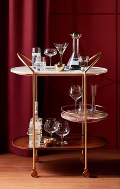 a bar cart with wine glasses on it