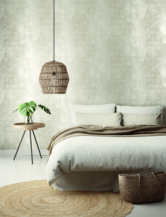 a bedroom with white walls and flooring has a bed, basket on the side