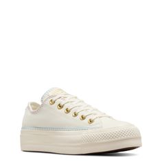 Be festival-ready with the unique detailing of these womens Converse Chuck Taylor All Star Lift Crafted Stitching egret/true sky/gold platform sneakers. Made of canvas upper, these low-top sneakers have a round cap toe, lace-up closure, and Decorative stitching details that wont go unnoticed. The All Star tongue label and All Star license plat at rear adds a vintage vibe while a studded daisy applique at heel lends a feminine touch. The OrthoLite cushioned footbed offers optimal comfort and mois Converse Canvas Platform Sneakers, Daisy Applique, Converse Platform, Low Top Converse, Chuck Taylor All Star Lift, Gold Platforms, Decorative Stitching, Stitching Details, Platform Sneaker