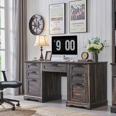 a desk with two drawers and a clock on it, in front of a window