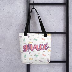 a white tote bag hanging on a wall with the word grace printed on it