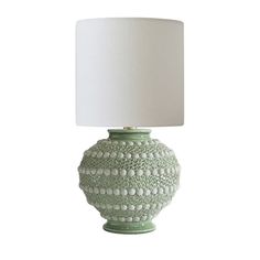 a green table lamp with a white shade