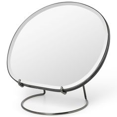 a round mirror sitting on top of a metal stand