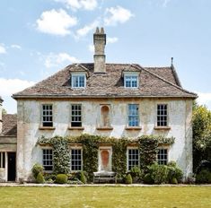 an old house with ivy growing all over it's sides and windows on the front