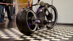 an unusual looking bike is on display in a room with black and white checkered flooring