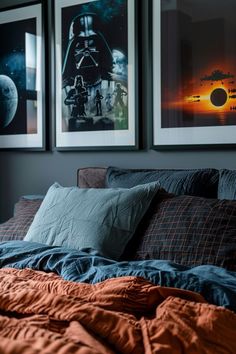 a bed with two pictures hanging on the wall above it and an orange comforter