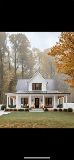 a white house with black shutters in the front yard and trees on either side