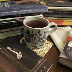 a cup of tea sitting on top of a table next to books