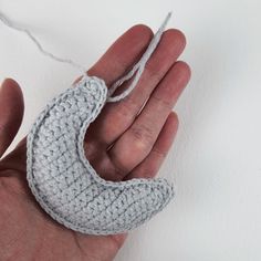 a hand holding a small crocheted object in it's palm