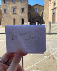 someone holding up a piece of paper with writing on it