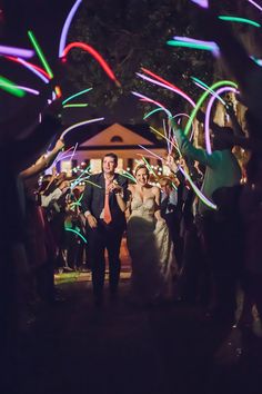 a bride and groom are walking through the sparkler tunnel