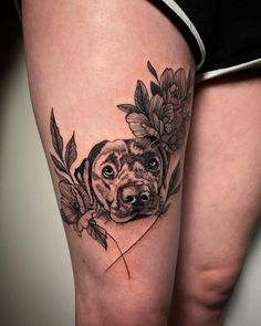 a woman's leg with a dog and flowers on it