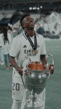 a soccer player is holding a trophy on the field