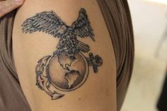 a woman's arm with a tattoo on it that has an eagle and globe