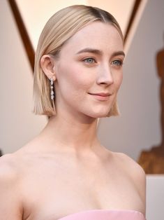 a woman with blonde hair and blue eyes in a pink dress at the oscars