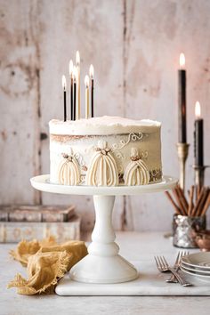 there is a cake with candles on it and some other items around the cake stand