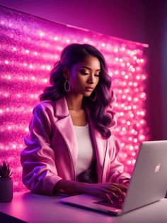 a woman sitting at a desk with a laptop computer in front of her and pink lights behind her