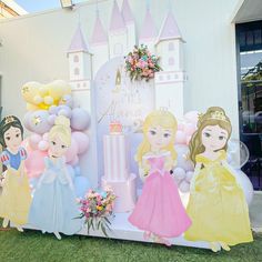 there are many princesses on display in front of the building that is decorated with balloons and streamers