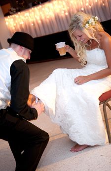 a man kneeling down next to a woman in a wedding dress