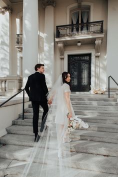 the bride and groom are walking down the stairs