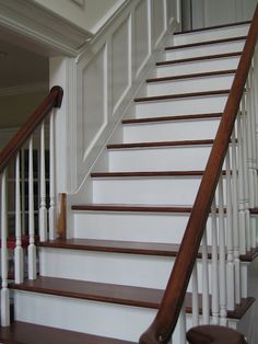 a white staircase with wooden handrails in a house