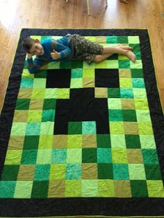 a man laying on top of a green and black quilt