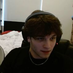 a young man wearing headphones while sitting on a couch