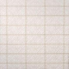 a white tiled wall with an intricate design